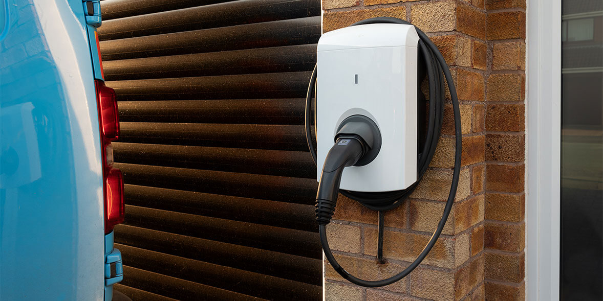 Modern EV wall charger installed on a brick wall